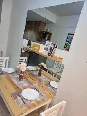 a dining room table with white plates and flowers on it at D'Annes Holistay in Manila