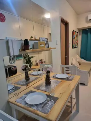 a kitchen with a wooden table with plates on it at D'Annes Holistay in Manila