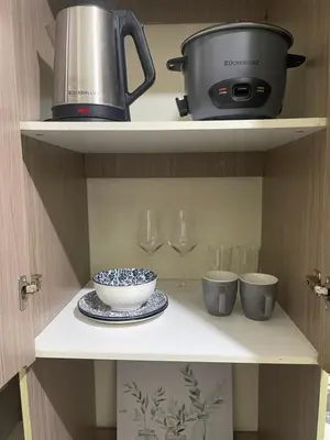 a shelf with a pot and wine glasses and a bowl at The Cozy Nook in Manila