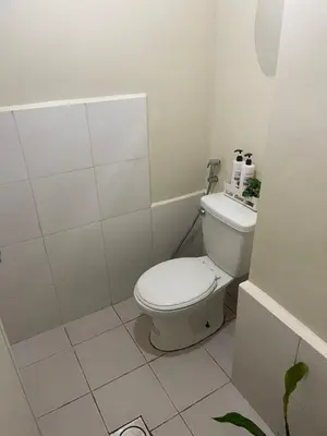 a bathroom with a white toilet in a room at The Cozy Nook in Manila