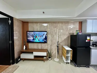 a living room with a television on a wall at Casa Doña at Kasara Urban Resort Residences in Manila