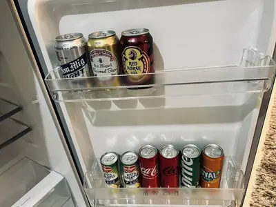 an open refrigerator filled with cans of soda at The Baylight Escape at Shore 2 in Manila