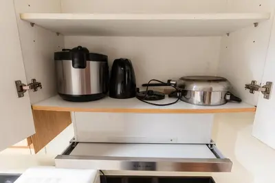 a kitchen with a stove and a pot on a shelf at shell residences condo walk to Mall of Asia in Manila
