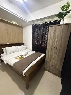 a bedroom with a bed with a wooden door at City Elite Retreats at Shore in Manila
