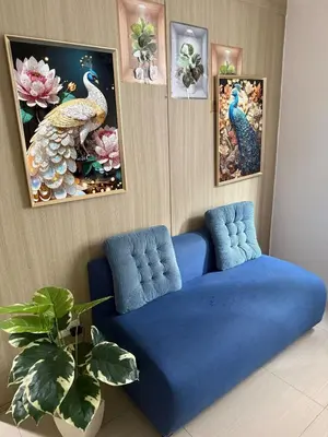 a living room with a blue couch and paintings at City Elite Retreats at Shore in Manila