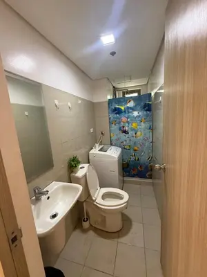 a bathroom with a toilet and a sink and a shower at City Elite Retreats at Shore in Manila