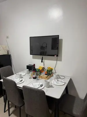 a white table with chairs and a television on a wall at The Tropical Haven at Shore in Manila