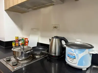 a kitchen counter with a tea kettle and two pans at The Tropical Haven at Shore in Manila