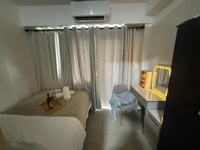 a small room with a bed and a mirror at The Tropical Haven at Shore in Manila