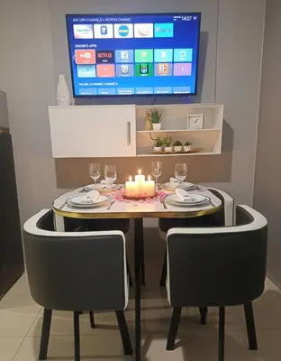 a dining room table with a candle and two chairs at Modern 1BRH Condotel Stunning City ViewSea Views in Manila