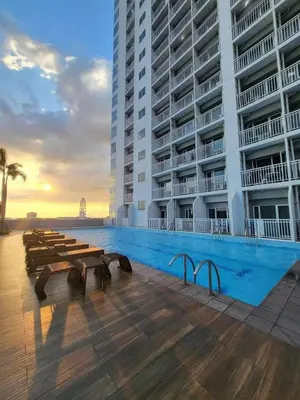 a large building with a swimming pool in front of a building at Modern 1BRH Condotel Stunning City ViewSea Views in Manila