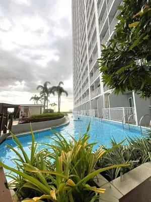 a swimming pool in front of a tall building at Modern 1BRH Condotel Stunning City ViewSea Views in Manila