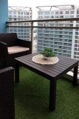 a wooden table with a potted plant on a balcony at Calme Corner Azure Urban Residences Maldives Tower in Manila