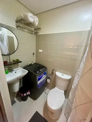 a bathroom with a white toilet and a sink at Le Trevi Suite at MOA Pasay Staycation in Manila