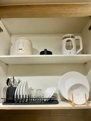 a shelf with plates and utensils in a kitchen at Le Trevi Suite at MOA Pasay Staycation in Manila