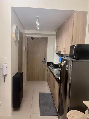a kitchen with a stainless steel refrigerator and a door at Le Trevi Suite at MOA Pasay Staycation in Manila