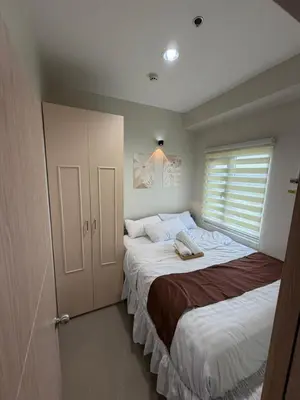 a bedroom with two beds and a window at Luxe staycation by Joy at Charm Residence Cainta in Manila