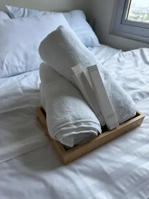 a stack of towels sitting on a bed at Luxe staycation by Joy at Charm Residence Cainta in Manila