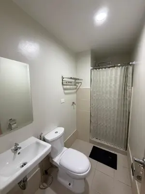 a bathroom with a toilet and a sink and a shower at Luxe staycation by Joy at Charm Residence Cainta in Manila