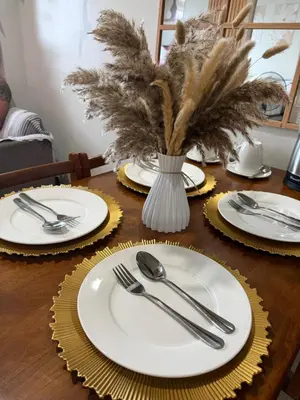 a wooden table with plates and silverware on it at Luxe staycation by Joy at Charm Residence Cainta in Manila