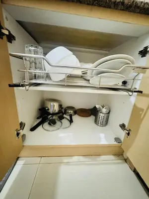 a cupboard with dishes and other kitchen utensils at Affordable Airport Staycation SMDC Field Residence in Manila