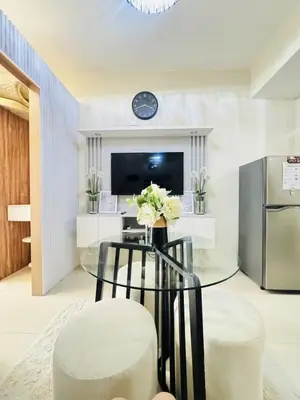 a dining room with a glass table and a refrigerator at Affordable Airport Staycation SMDC Field Residence in Manila