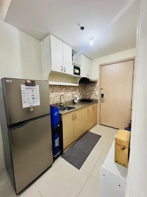 a kitchen with a stainless steel refrigerator and cabinets at Affordable Airport Staycation SMDC Field Residence in Manila