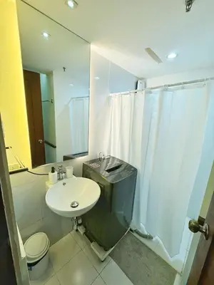 a bathroom with a sink and a toilet and a shower at Casa Rosie in Seibu Tower - homey 1BR near BGC High Street in Manila
