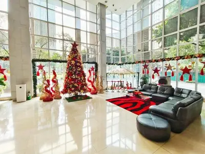 a living room with a christmas tree in a building at Casa Rosie in Seibu Tower - homey 1BR near BGC High Street in Manila