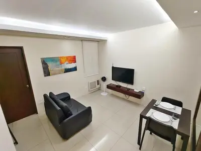a living room with a couch and a television at Casa Rosie in Seibu Tower - homey 1BR near BGC High Street in Manila