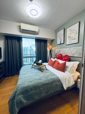 a bedroom with a large bed with red pillows at Pahinga Luxury Stays in Manila