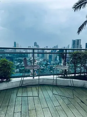 two chairs on a balcony with a view of a city at Pahinga Luxury Stays in Manila