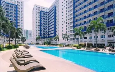 a swimming pool with a row of chairs and buildings at NEAR SMX, MOA Sea Residence Condotel in Manila