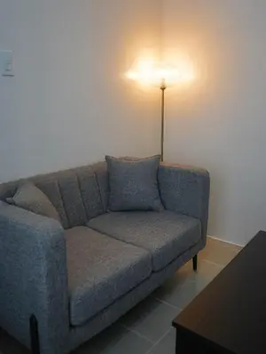 a living room with a couch and a lamp at Maison Inea in Manila