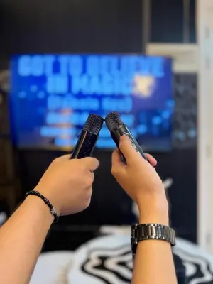 a person holding two cell phones in their hands at Azure Staycation by Adie Luxe Haven in Manila