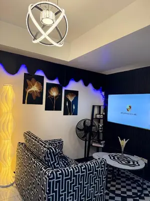 a living room with a couch and a screen at Azure Staycation by Adie Luxe Haven in Manila