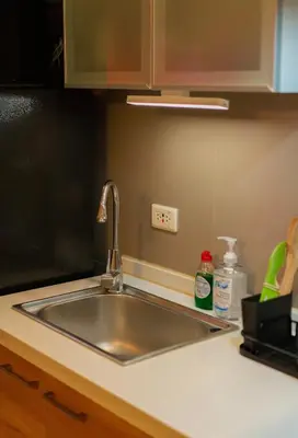 a kitchen counter with a sink in a kitchen at Spacious 1-BR Condo near BGC w Pool and Gym in Manila
