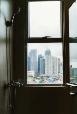 a bathroom window with a view of a city skyline at Spacious 1-BR Condo near BGC w Pool and Gym in Manila