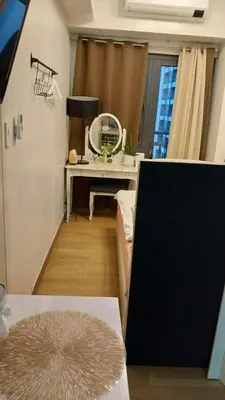 a living room with a desk and a mirror at MCStaycation at Spring Residence Near Airport in Manila