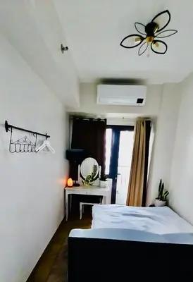 a bedroom with a bed and a ceiling fan at MCStaycation at Spring Residence Near Airport in Manila