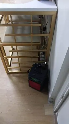 a suitcase sitting on the floor under a desk at MCStaycation at Spring Residence Near Airport in Manila