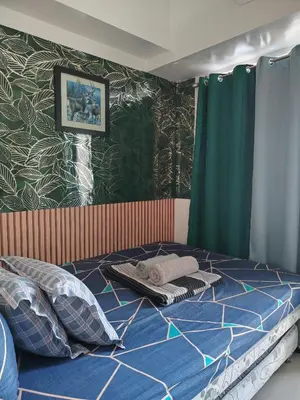 a bedroom with a bed with a blue comforter at Sea Residences Feliz in Manila