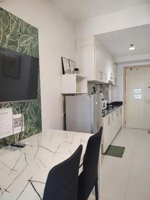 a kitchen with two chairs and a refrigerator at Sea Residences Feliz in Manila