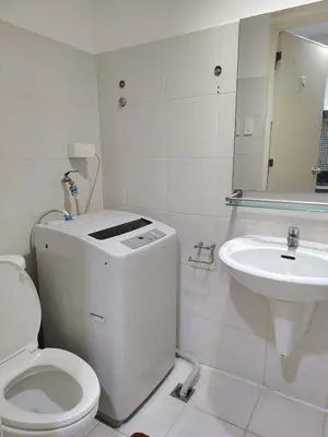 a white bathroom with a toilet and a sink at Sea Residences Feliz in Manila