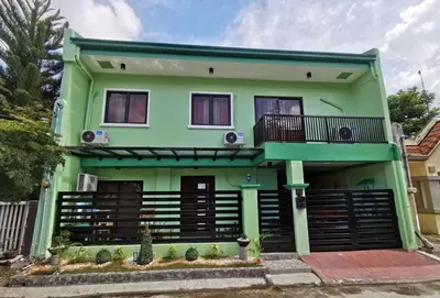 a green house with a balcony at Private Room Casa de los Reyes Kings' HouseHomestay in San Pedro