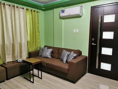 a living room with a brown couch and a door at Private Room Casa de los Reyes Kings' HouseHomestay in San Pedro