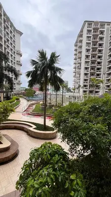 a palm tree in a park with two tall buildings at Solemare Parksuites -Tower C in Manila