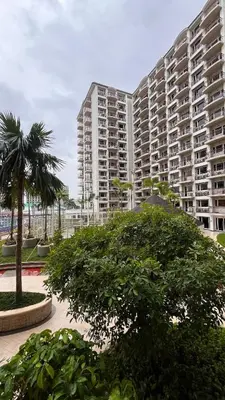 a large apartment building with a palm tree in the foreground at Solemare Parksuites -Tower C in Manila