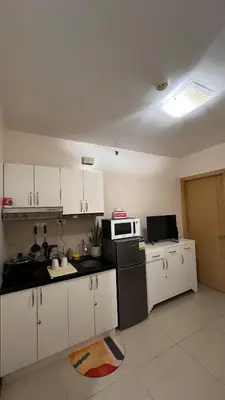 a kitchen with white cabinets and a microwave at Solemare Parksuites -Tower C in Manila