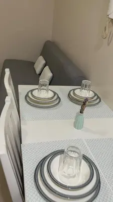 a table with two plates and glasses on it at Solemare Parksuites -Tower C in Manila
